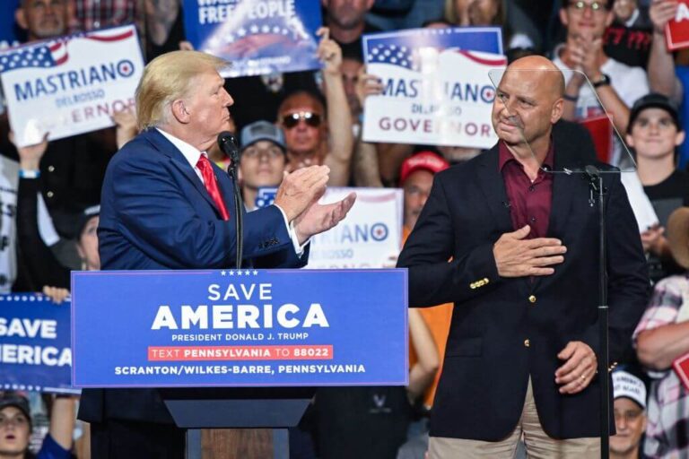 Former President Donald Trump, left, applauds Pennsylvania gubernatorial candidate Doug Mastriano during a campaign rally on Sept. 3, 2022.