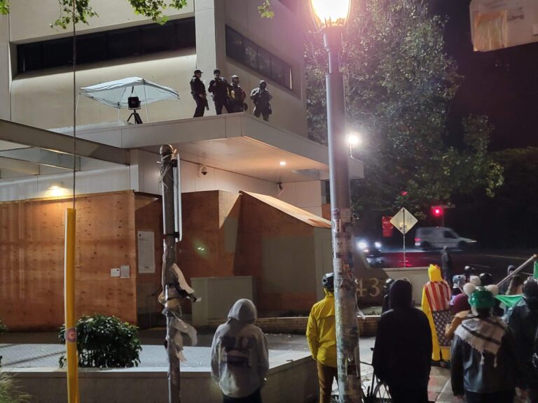 אַ מוצאי־שבת אין פּאָרטלאַנד, אַ קאַצנשפּרונג פֿונעם „אײַס“־בניןUn samedi soir à Portland, tout près du bâtiment ICE